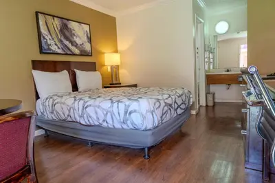 a bedroom with a bed and a desk and a sink at National 9 Inns in Buttonwillow