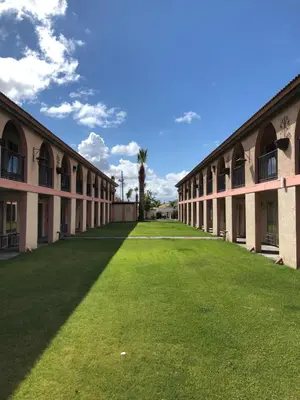 an empty courtyard of a building with a grass yard at National 9 Inns in Buttonwillow