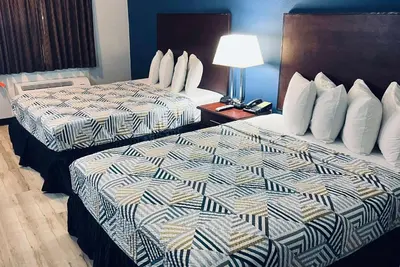 two beds sitting next to each other in a hotel room at Baymont by Wyndham Ridgecrest in Ridgecrest
