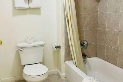 a bathroom with a toilet and a bath tub at Baymont by Wyndham Ridgecrest in Ridgecrest
