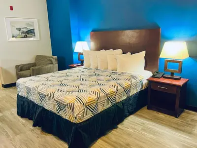 a hotel room with a bed and a telephone at Baymont by Wyndham Ridgecrest in Ridgecrest