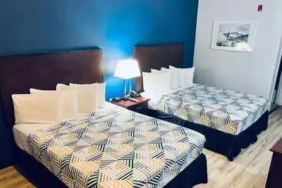 two beds in a hotel room with blue walls at Baymont by Wyndham Ridgecrest in Ridgecrest