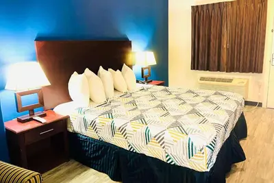 a large bed in a hotel room with two lamps at Baymont by Wyndham Ridgecrest in Ridgecrest