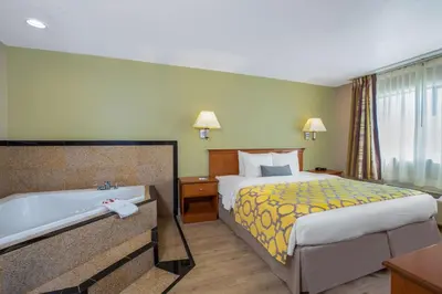 a hotel room with a bed and a bath tub at Baymont by Wyndham Tehachapi in Tehachapi