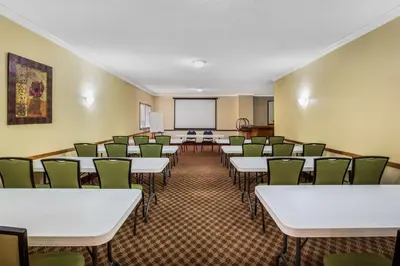 a room with rows of tables and green chairs at Baymont by Wyndham Tehachapi in Tehachapi