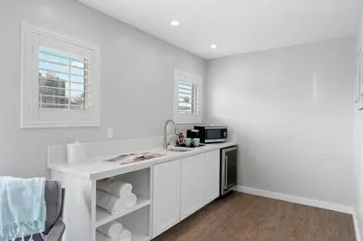 a white kitchen with a sink and a microwave at Sea Sprite Beach Club in Hermosa Beach