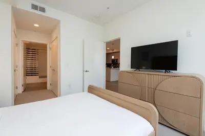 a bedroom with a bed and a flat screen tv at Modern Apartment Rentals in Los Angeles