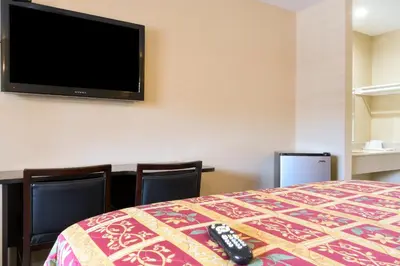 a hotel room with a bed and a flat screen tv at Covina Motel in West Covina
