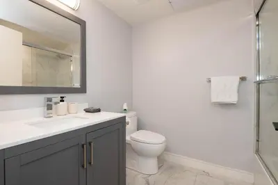 a bathroom with a toilet and a sink and a mirror at Regency Modern Apartments in Glendale