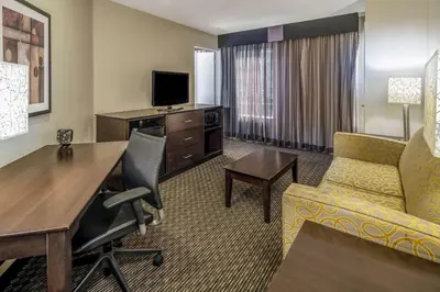 a hotel room with a desk and a living room at La Quinta by Wyndham Anaheim in Anaheim