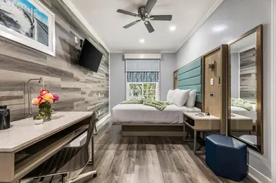 a hotel room with a bed and a desk with flowers at Lumea by the Sea Long Beach Convention Center in Long Beach