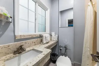 a bathroom with a sink and a toilet and a window at Lumea by the Sea Long Beach Convention Center in Long Beach