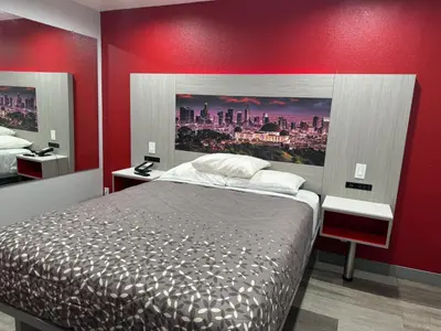 a bedroom with a bed and a red wall at Lincoln Motel - Los Angeles, Hollywood Area in Pasadena