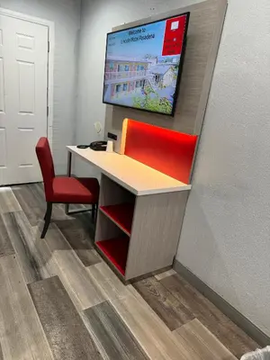 an office with a desk and a tv on a wall at Lincoln Motel - Los Angeles, Hollywood Area in Pasadena