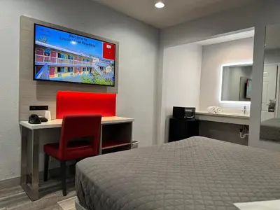 a bedroom with a bed and a desk and a television at Lincoln Motel - Los Angeles, Hollywood Area in Pasadena
