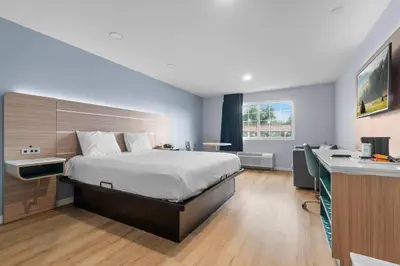 a bedroom with a bed and a desk in a room at Travelodge by Wyndham Fairplex Pomona in Pomona
