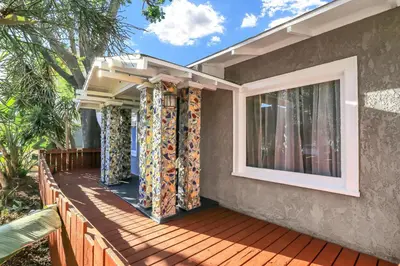a house with a wooden deck with curtains on it at Long Beach House in Long Beach