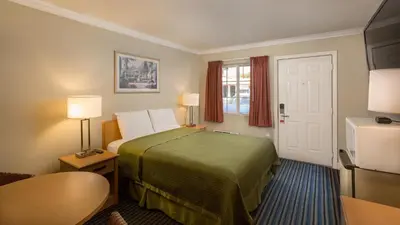 a hotel room with a bed and a window at Harbor Motel in Anaheim