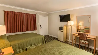 a hotel room with a bed and a desk at Harbor Motel in Anaheim