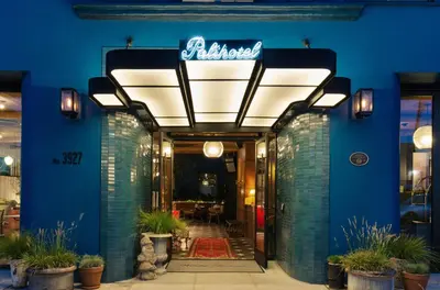 a restaurant entrance with a blue wall and a neon sign at Palihotel Culver City in Los Angeles