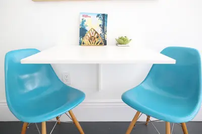 a white table with two blue chairs next to it at The Burlington in Los Angeles