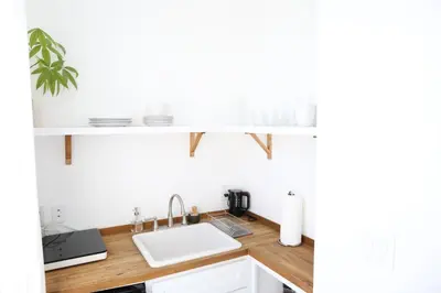 a kitchen with a white shelf above a sink at The Burlington in Los Angeles