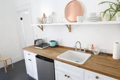 a kitchen with white cabinets and a sink and a counter at The Burlington in Los Angeles