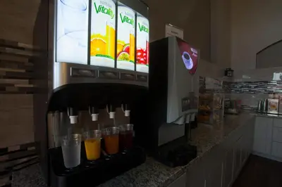 a drink dispenser in a store with drinks in cups at Ramada by Wyndham Barstow in Barstow