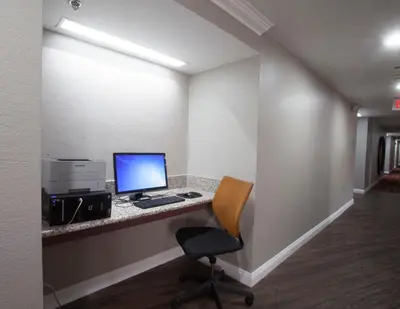 an office with a desk with a computer and a chair at Ramada by Wyndham Barstow in Barstow