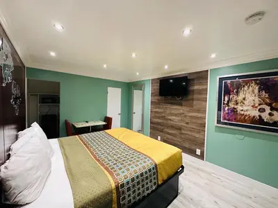a bedroom with a bed and a flat screen tv at Casa Blanca Inn - Whittier, Los Angeles in Whittier