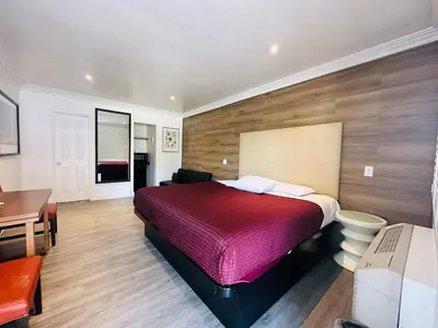 a bedroom with a red bed and a desk at Casa Blanca Inn - Whittier, Los Angeles in Whittier
