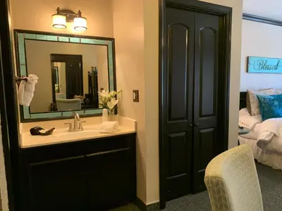 a bathroom with a sink and a mirror and a bed at The North Shore Inn in Crestline