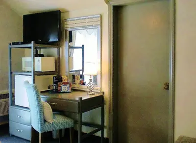 a room with a desk with a chair and a window at The North Shore Inn in Crestline