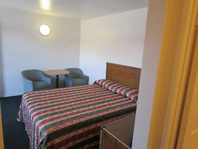 a hotel room with a bed and a table at Welcome Inn & Suites Anaheim in Anaheim