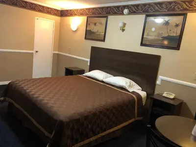 a hotel room with a bed and a telephone at Whittier Travel Inn in Whittier