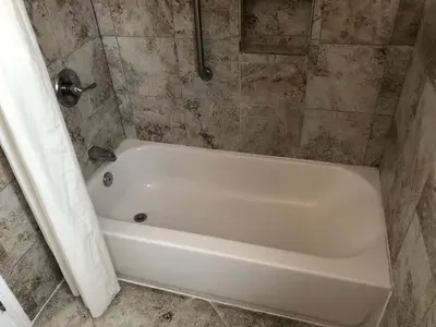 a white bath tub in a tiled bathroom at Whittier Travel Inn in Whittier