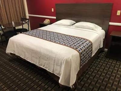 a bedroom with a large bed with a wooden headboard at Whittier Travel Inn in Whittier