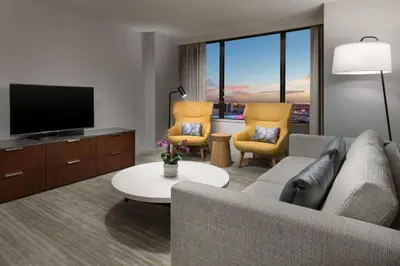 a living room with a couch and a flat screen tv at The Westin Long Beach in Long Beach