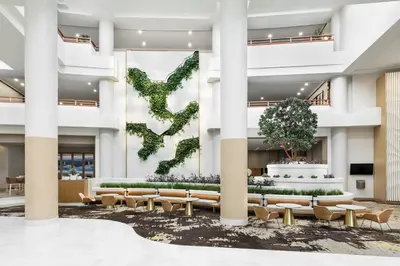 a lobby with a large green ivy wall at The Westin Long Beach in Long Beach