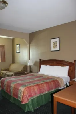 a hotel room with a bed and a couch at Holland Inn and Suites in Taft