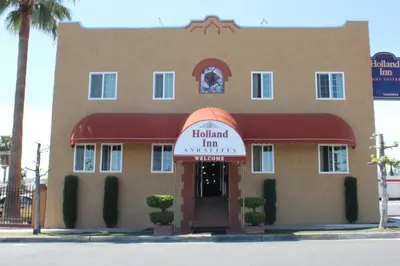 a building with a sign that reads hollywood inn navarre at Holland Inn and Suites in Taft