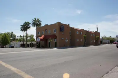 an empty street in front of a brown building at Holland Inn and Suites in Taft