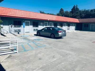 a car parked in a parking lot in front of a building at Rocky Inn Motel in Lynwood