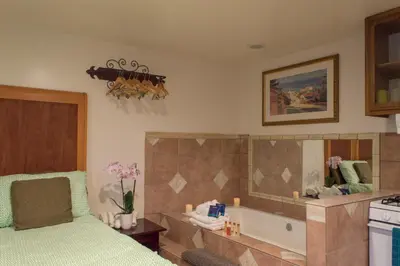 a bedroom with a bed and a tub and a mirror at Casa Del Sol in Carpinteria