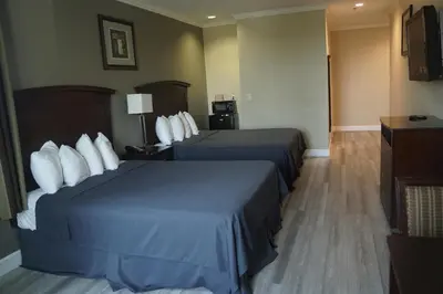 a hotel room with two beds and a television at Harbor Inn & Suites in Anaheim