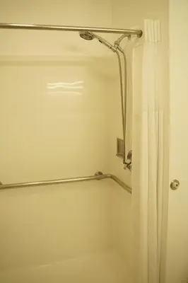 a bathroom with a shower with a shower curtain at Harbor Inn & Suites in Anaheim