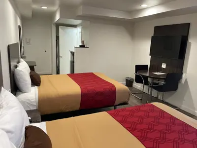 a hotel room with two beds and a desk at Claremont Lodge in Claremont