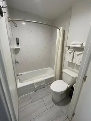 a bathroom with a toilet and a tub and a sink at Claremont Lodge in Claremont
