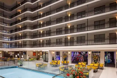 a large building with a pool and tables and chairs at Embassy Suites by Hilton Anaheim North in Anaheim