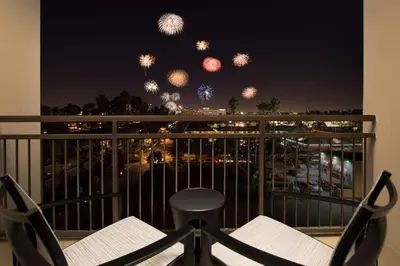 a balcony with a table and chairs and fireworks at Hampton Inn & Suites Anaheim Garden Grove in Anaheim
